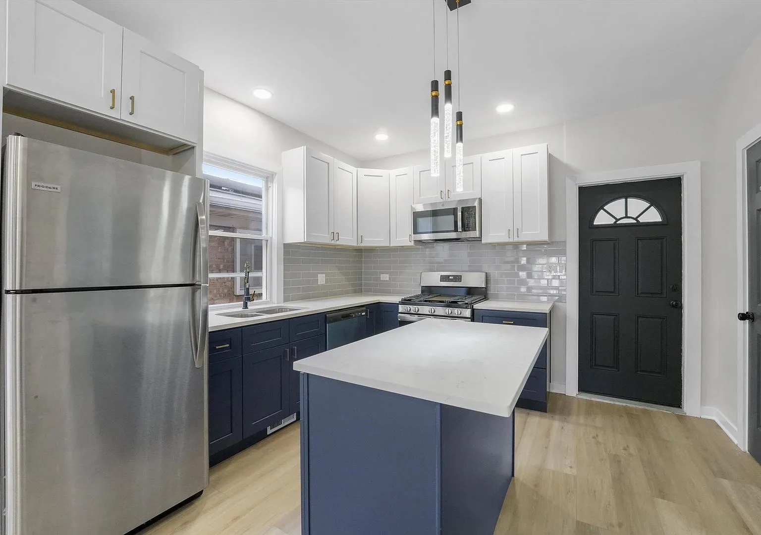 Remodeled kitchen with navy island, white cabinets and quartz counters, Portage Park Chicago