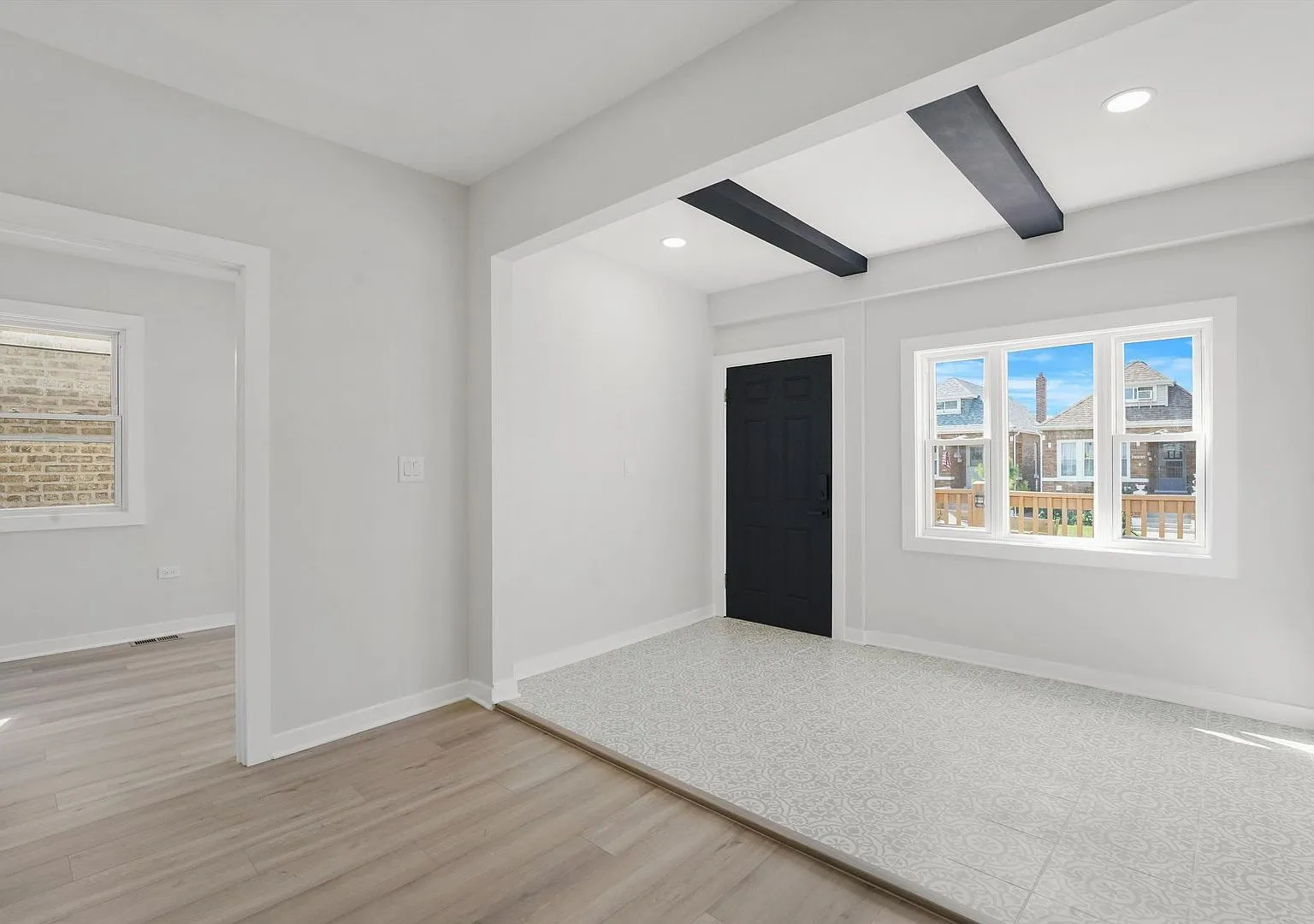 Living room with ceiling beams and new flooring after renovation, Portage Park case study